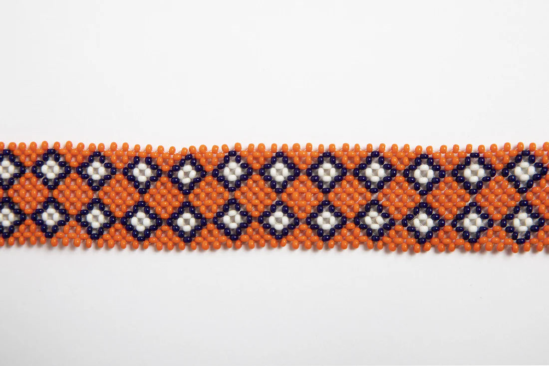 Bandoulière en perles colorées "Alvaro" dans la couleur "Karuma Orange." Disponible en plusieurs autres coloris, avec certains modèles uniques. Longueur de 115 à 120 cm. Fabriquée à la main au Kenya: