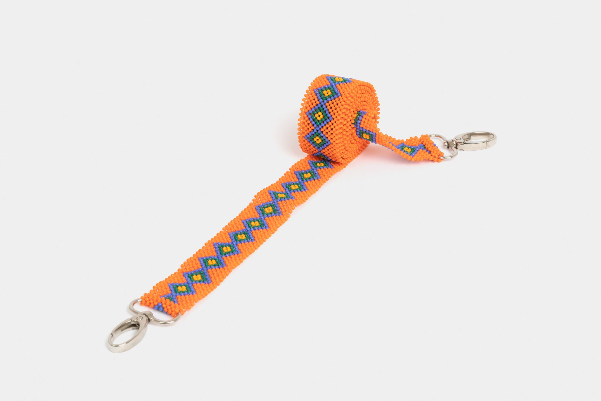 Bandoulière en perles colorées "Alvaro" dans la couleur "Kikuyu Orange." Disponible en plusieurs autres coloris, avec certains modèles uniques. Longueur de 115 à 120 cm. Fabriquée à la main au Kenya: