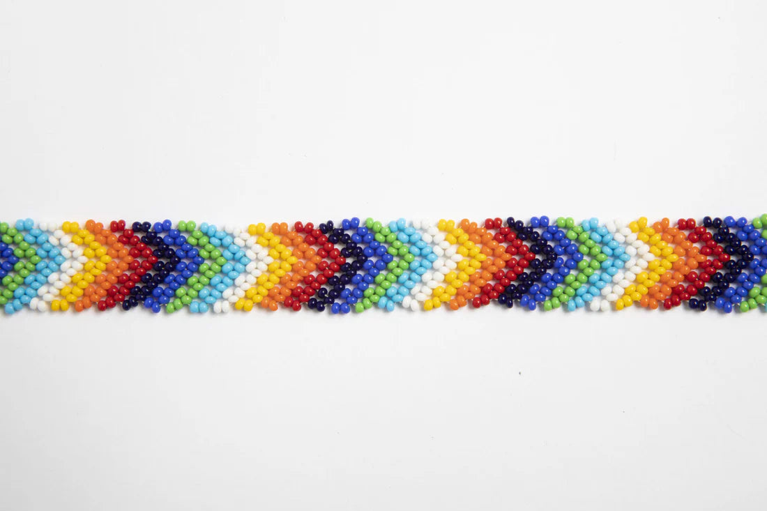 Bandoulière en perles colorées "Alvaro" dans la couleur "Multicolor Arrows." Disponible en plusieurs autres coloris, avec certains modèles uniques. Longueur de 115 à 120 cm. Fabriquée à la main au Kenya: