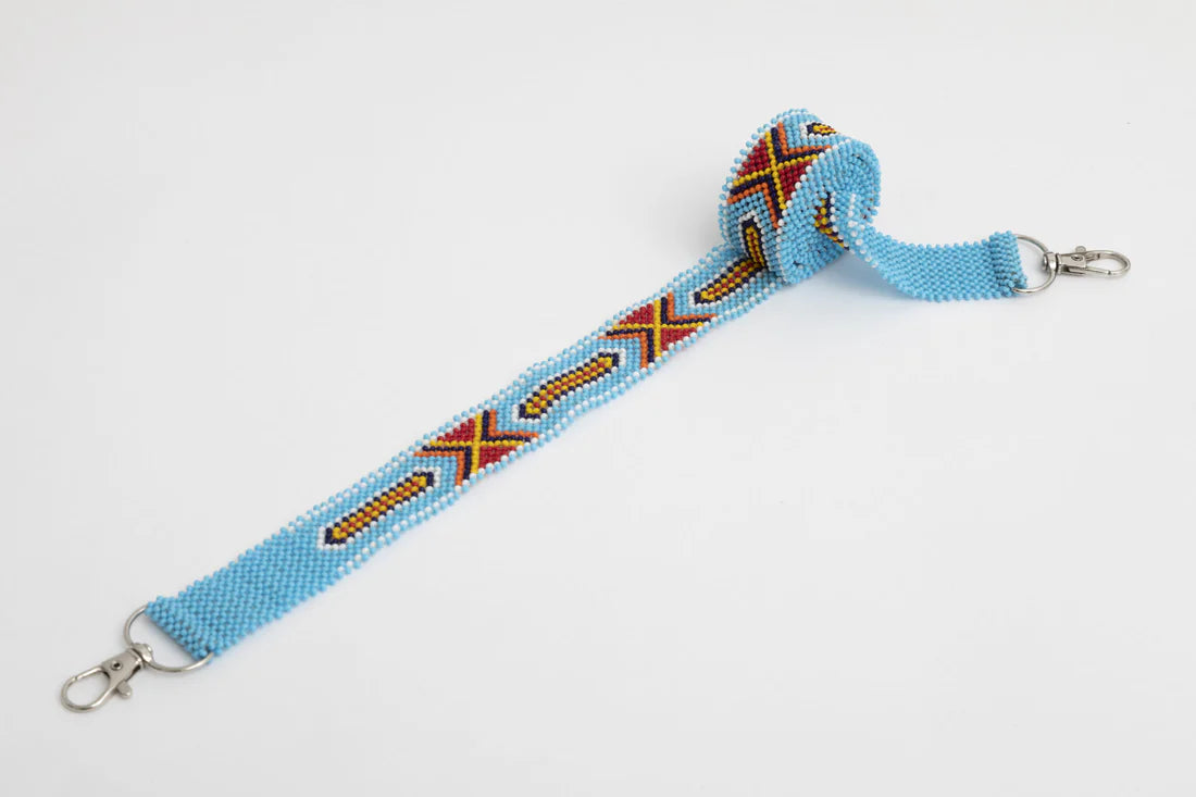 Bandoulière en perles colorées "Alvaro" dans la couleur "Amboseli Light Blue." Disponible en plusieurs autres coloris, avec certains modèles uniques. Longueur de 115 à 120 cm. Fabriquée à la main au Kenya: