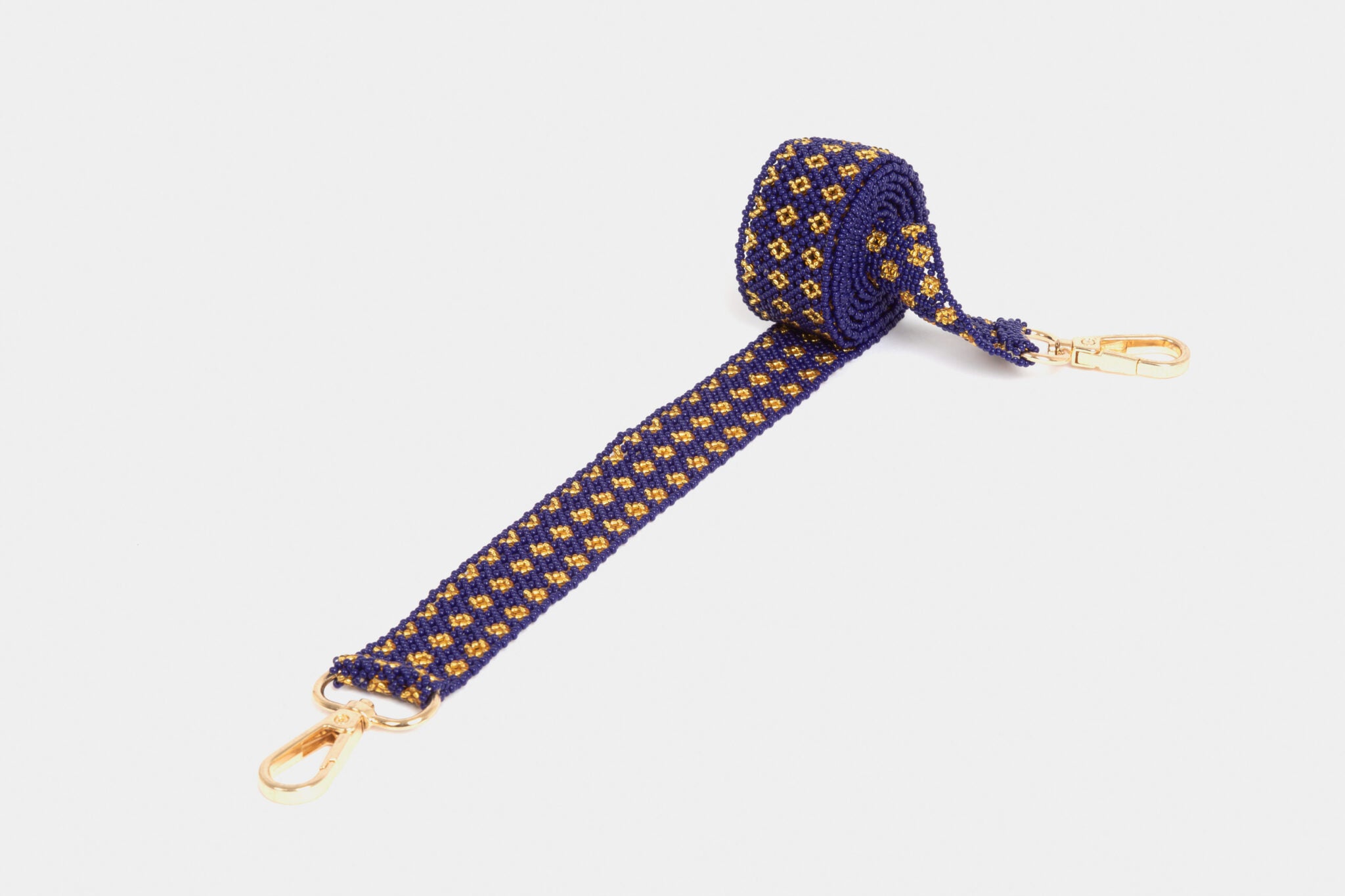 Bandoulière en perles colorées "Alvaro" dans la couleur "Elegant Gold." Disponible en plusieurs autres coloris, avec certains modèles uniques. Longueur de 115 à 120 cm. Fabriquée à la main au Kenya: