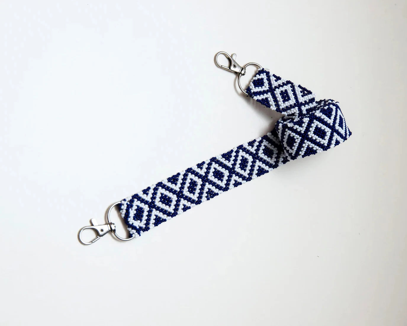 Bandoulière en perles colorées "Alvaro" dans la couleur "Josephat White & Blue." Disponible en plusieurs autres coloris, avec certains modèles uniques. Longueur de 115 à 120 cm. Fabriquée à la main au Kenya: