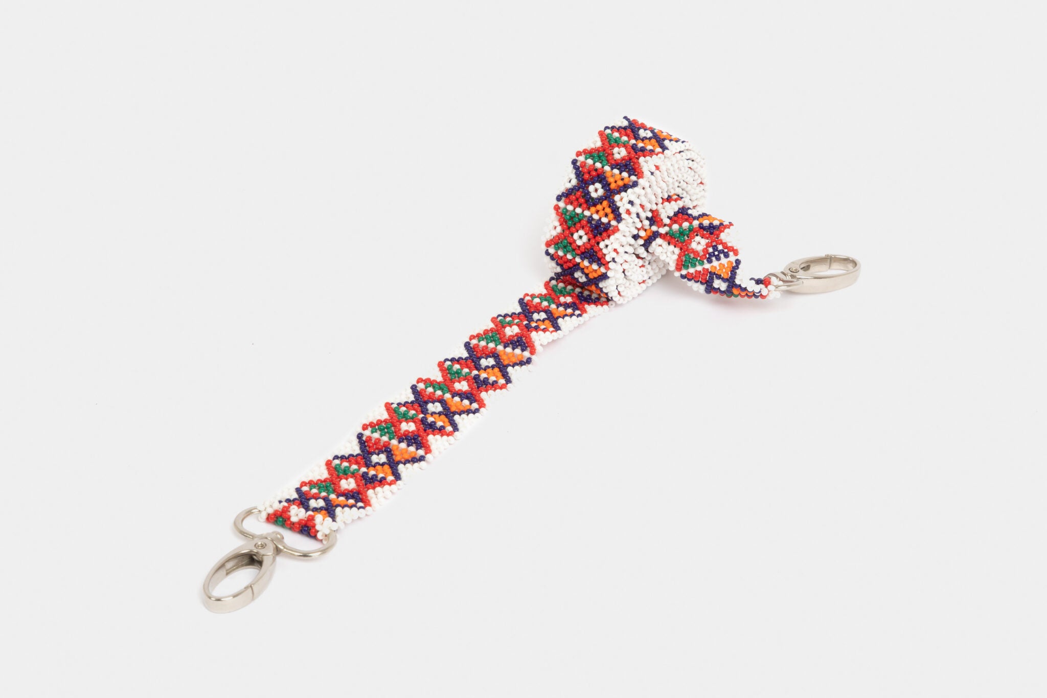 Bandoulière en perles colorées "Alvaro" dans la couleur "Matunda." Disponible en plusieurs autres coloris, avec certains modèles uniques. Longueur de 115 à 120 cm. Fabriquée à la main au Kenya: