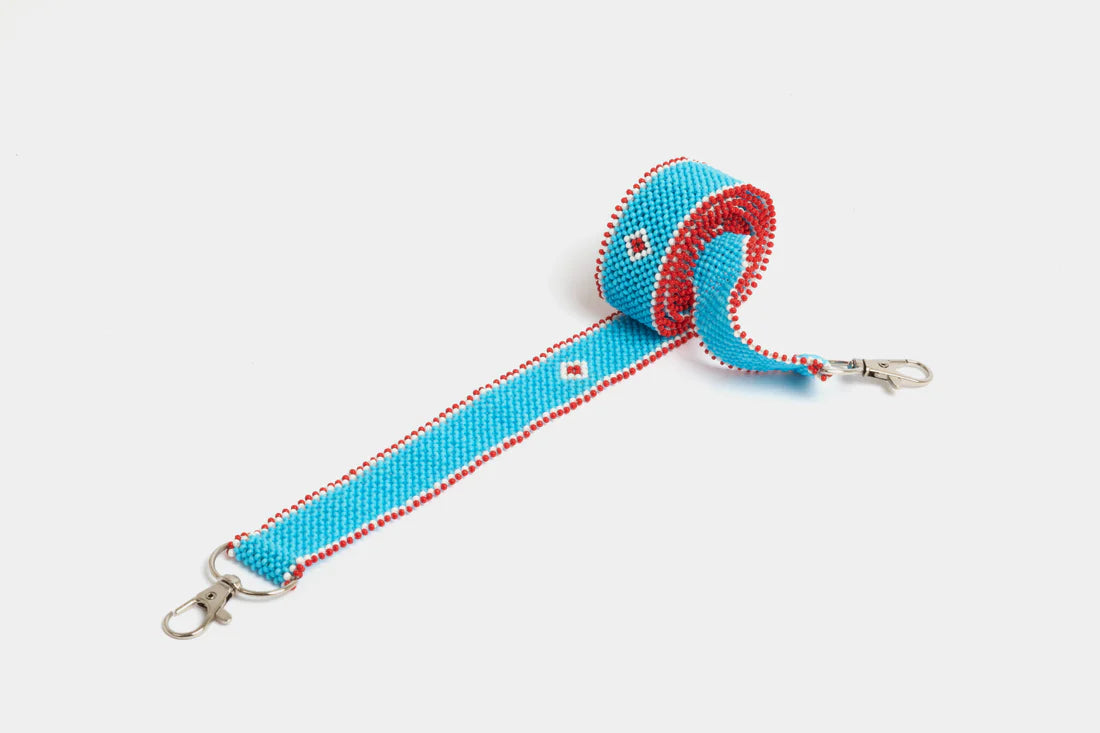 Bandoulière en perles colorées "Alvaro" dans la couleur "Simple Light Bleu." Disponible en plusieurs autres coloris, avec certains modèles uniques. Longueur de 115 à 120 cm. Fabriquée à la main au Kenya: