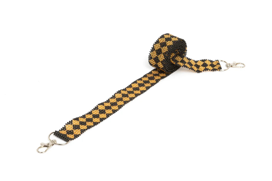 Bandoulière en perles colorées &quot;Alvaro&quot; dans la couleur &quot;Black &amp; Gold.&quot; Disponible en plusieurs autres coloris, avec certains modèles uniques. Longueur de 115 à 120 cm. Fabriquée à la main au Kenya: